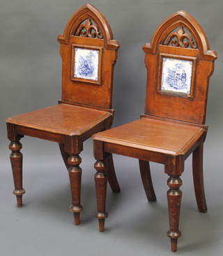 A pair of Victorian mahogany Gothic style hall chairs, the backs inset blue and white tiles with solid seats raised on turned supports 