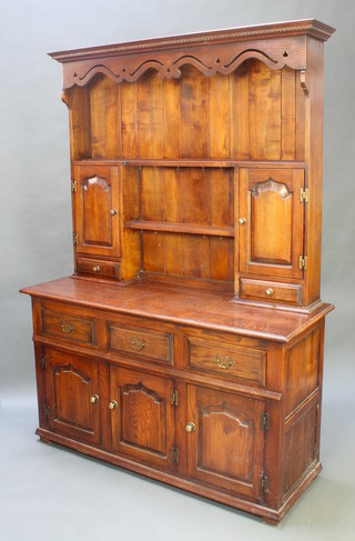 A 17th/18th Century oak style oak dresser, the raised back with moulded and pierced cornice above shelves flanked by cupboards enclosed by a panelled door with drawer beneath, the base fitted 3 long drawers above 3 arched panelled doors, 76 1/2"h x 54"w x 20"d  