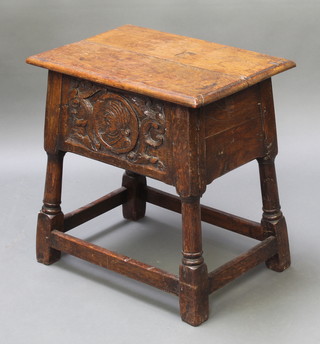 A rectangular carved oak joined stool/storage box with hinged lid, the top of plank construction, the apron carved a figure of a classical man raised on turned and block supports 21" x 20 1/2" x 14"d 