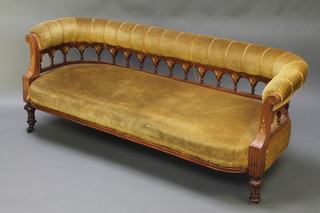 A Victorian carved walnut show frame sofa upholstered in yellow material, raised on turned supports 25"h x 70"w x 23"d 