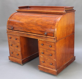A Victorian mahogany cylinder bureau with three-quarter gallery the interior fitted pigeon holes and sliding writing surface above 6 long drawers 50"h x 53"w x 30"d 