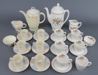 A Susie Cooper part coffee set decorated with stylised flowers comprising coffee pot, 6 coffee cups, a cream jug, sugar bowl and 6 saucers together with a Royal Doulton Woodland pattern ditto comprising 6 coffee cups, 5 saucers, milk jug, sugar bowl and coffee pot 
