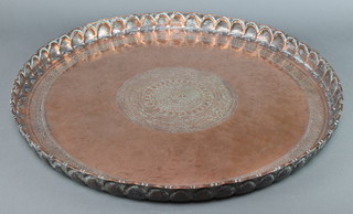 A circular Eastern copper charger with raised rim 2"h x 27" diam. 