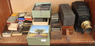 A magic lantern converted to electricity together with a large collection of magic lantern slides, some contained in wooden boxes and some loose 
