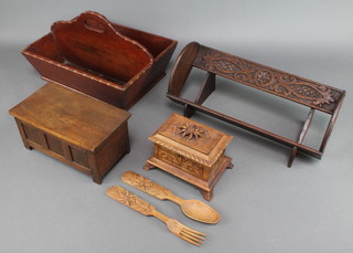 A 19th Century rectangular mahogany twin division cutlery tray 7" x 14" x 10" (a small section of timber missing to the side), a miniature oak coffer 4" x 9 1/2" x 5", a Victorian carved oak trinket box with hinged lid raised on bracket feet 4" x 6 1/2" x 4", a pair of carved wooden salad servers and a carved oak book trough 6" x 15" x 7" 