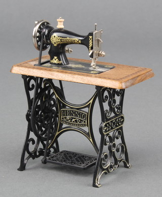 A miniature metal and wooden model of a treadle sewing machine 3" x 3 1/2" x 1 1/2"  