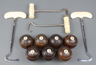 Seven Taylor-Rolph lignum vitae and ivory carpet bowls together with 2 chrome and bone mounted boot hooks 