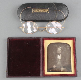 A daguerreotype of a seated gentleman 3" x 2 1/2" in a plush frame together with a slip of paper marked Captain Aytom and a pair of spectacles in a gilt case 