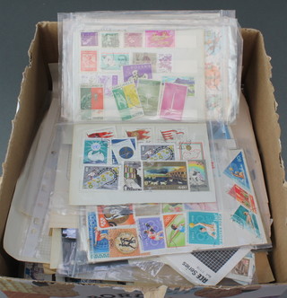 A box of loose mint and used world stamps, some on envelopes