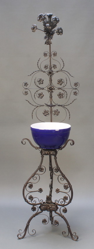 An Italian wrought iron wash stand, the raised back with jug hook and soap dish, raised on 3 pierced supports 65"h x 17"w x 14"d together with an associated blue wash bowl 