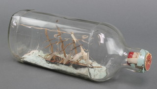 A 3 masted wooden ship in a bottle contained in a W M Teachers & Sons bottle 4"h x 10 1/2"l x 3"w 