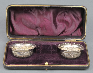 A pair of Victorian repousse silver table salts decorated with scrolls  Birmingham 1894 15 grams 