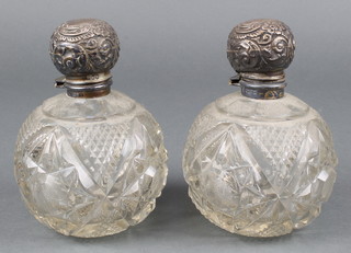 A pair of Edwardian silver mounted spherical cut glass scent bottles with repousse lids Chester 1907 5 1/2" 