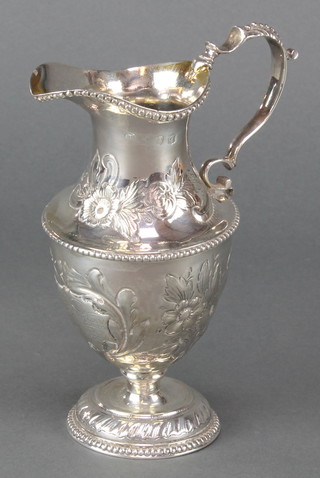 A George III silver cream jug with repousse scroll decoration and presentation inscription, rubbed hallmarks 182 grams 7"