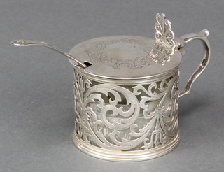 A Victorian silver mustard with chased scroll lid and pierced body with S scroll handle London 1847 together with a spoon 146 grams 