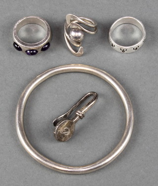 A silver bangle, 3 silver rings and a napkin holder 43 grams