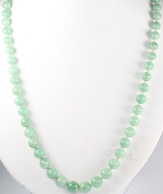 A string of graduated jade beads with a yellow gold clasp 21"