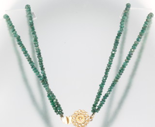 A double strand of faceted emerald beads with gilt clasp