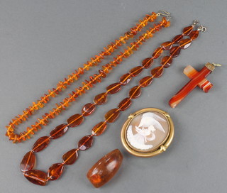 A Victorian gilt mounted cameo brooch, natural amber bead brooch, 2 necklaces and a hardstone cross 