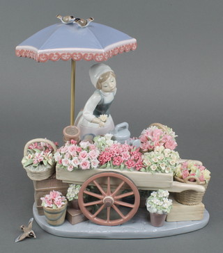 A large Lladro group of a girl flower seller before a barrel of flowers beneath a parasol 11" 