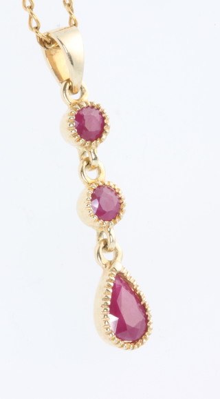 A 9ct yellow gold 3 stone ruby drop pendant and chain 