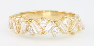 An 18ct yellow gold diamond ring, set with brilliant and tapered baguette cut diamonds size M 