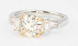 An 18ct 2 colour gold diamond ring, the centre brilliant cut stone approx 1.57ct, colour L, clarity VS1 the shoulders set with tapered baguettes and baguette cut diamonds, approx 1.0ct, size L, with EDR certificate 