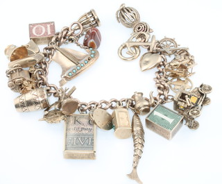 A 9ct yellow gold charm bracelet with 29 charms, gross weight 84 grams 