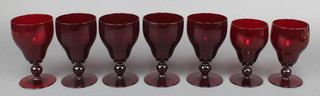A matched set of 7 red glass wine glasses 