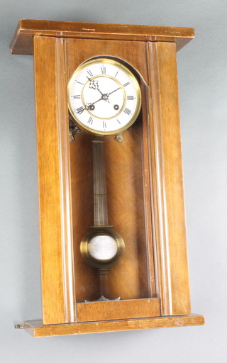 A Vienna style regulator with circular enamelled dial, Roman numerals and grid iron pendulum contained in a walnut case 