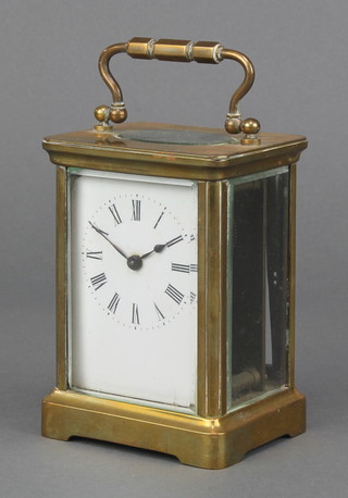 A  19th Century French 8 day carriage timepiece with enamelled dial and Roman numerals contained in a gilt metal case 