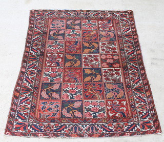 A Persian red and blue ground Bakhtiari carpet, the central ground formed of 28 panels with floral decoration 82 1/2" x 63" 