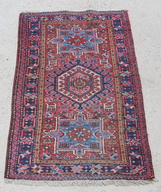 A Persian Karajeh rug with stylised diamond and medallion to the centre 56" x 34"