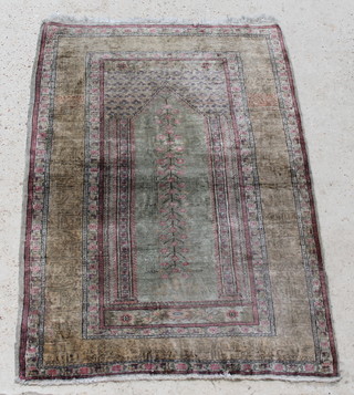 A silk Qum rug with green ground, in wear, 64" x 37" 