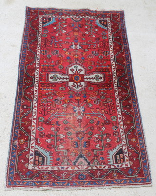A tan and white ground Persian Nahavand rug with central medallion 81" x 43"