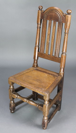 A 17th/18th Century stick and bar back hall chair with solid seat raised on turned and block supports
