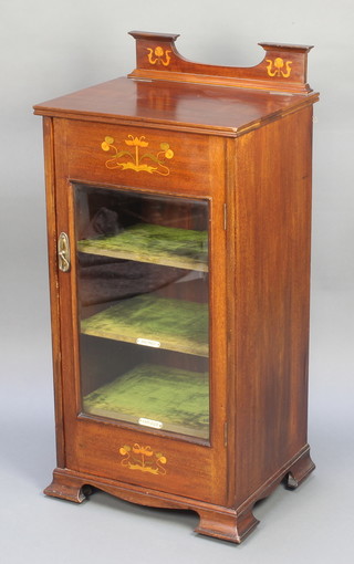 An Edwardian Art Nouveau inlaid mahogany music cabinet the hinged lid fitted a recess, fitted shelves and enclosed by a glazed panelled door, raised on ogee bracket feet 40"h x 18 1/2"w x 16"d 
