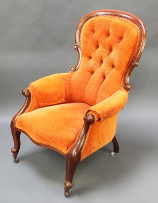 A Victorian mahogany show frame armchair upholstered in buttoned corderoy burnt orange material, raised on cabriole supports  
