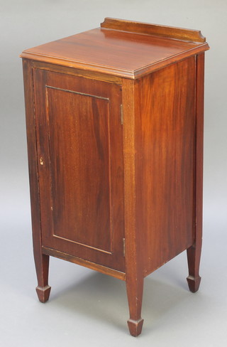 An Edwardian mahogany bedside cupboard with raised back enclosed by a panelled door, raised on square supports with spade feet 31"h x 15"w x 14"d 