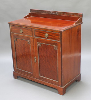 An Edwardian Chippendale style carved mahogany wash stand, the raised back with Grecian key decoration fitted 2 drawers above a double cupboard enclosed by panelled doors, raised on bracket feet 39"h x 36"w x 20"d 
