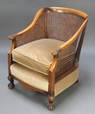 A beech tub back bergere chair with egg and claw arms raised on cabriole supports 