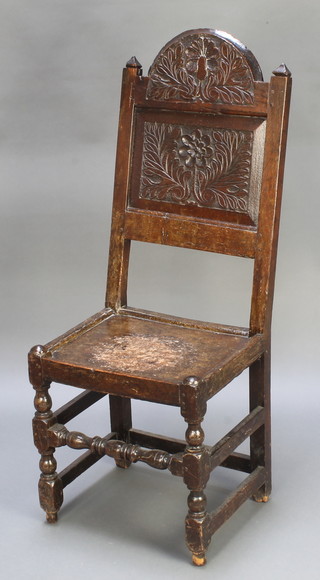 An 18th Century carved oak high back hall chair with solid seat raised on turned and block supports 
