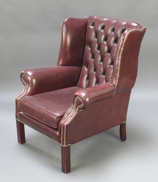 A Georgian style armchair upholstered in red buttoned leather 