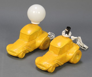 A pair of Continental yellow painted pottery table lamps in the form of Hot Rods