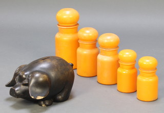 A pottery piggy bank and 5 graduated orange glass lidded bottles