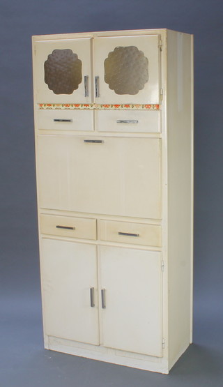 A 1950's cream painted kitchen cabinet enclosed by glazed panelled doors above 2 short drawers, a fall front, 2 short drawers and a double cupboard 69"h x 30"w x 17"