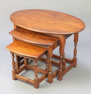 An oak oval nest of 3 interfitting coffee tables raised on turned supports 21"h x 31"w 