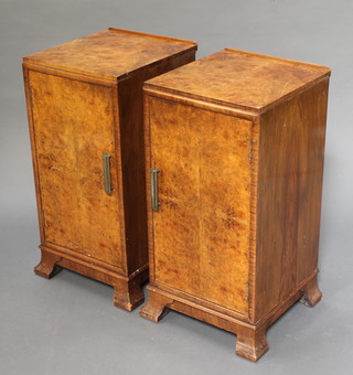 A pair of Art Deco figured walnut bedside cabinets enclosed by panelled doors raised on splayed feet 28"h x 14"w x 14 1/2"d 