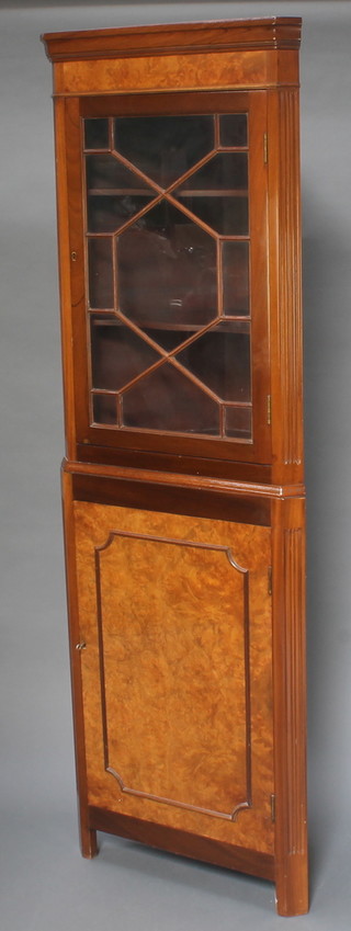 A Georgian style figured walnut double corner cabinet, the upper section with moulded cornice enclosed by astragal glazed panelled doors, the base enclosed by a panelled door, raised on square supports 68"h x 22 1/2"w x 13"d 
