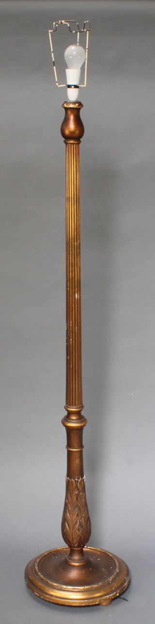 A gilt reeded standard lamp raised on a circular base 60"h base 14" diam. 